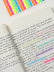 Λεπτομερής προβολή πολύχρωμων εξαιρετικά λεπτών καρτελών PET που εφαρμόζονται σε σελίδες βιβλίων