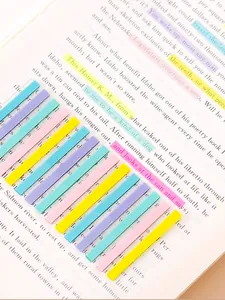 Colorful transparent narrow index sticky notes used as highlighters on book pages for study