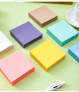Vista dettagliata di post-it trasparenti color Morandi disposti su una superficie verde