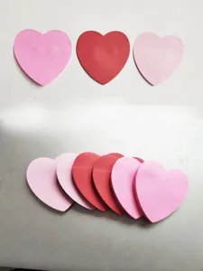 Gros plan de post-it en forme de cœur dans diverses nuances de rose et de rouge vif