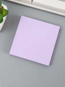 Nahaufnahme eines lavendelfarbenen Macaron-Haftnotizblocks auf einem grauen Tisch