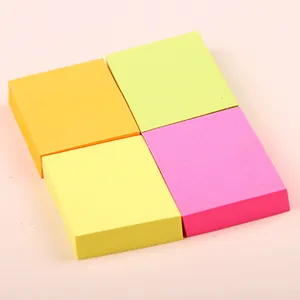 Set of four colorful fluorescent square sticky notes in orange green yellow and pink