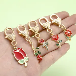 Close-up of five varied red rose alloy keychains with heart-shaped golden clasps