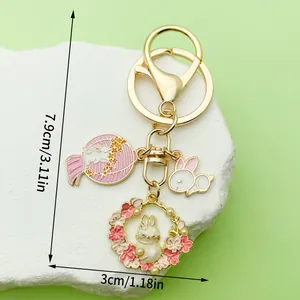 Detalle de dimensiones del llavero de conejo dorado con dijes de flores de cerezo