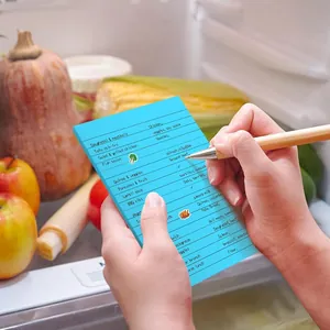 Large blue lined sticky note pad used for grocery list inside a refrigerator