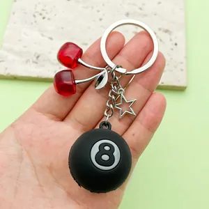 Detail view of cherry and 8-ball keychain with resin fruits and silver star charm