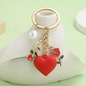 Detail view of heart and rose keychain with pearl charm on white textured base
