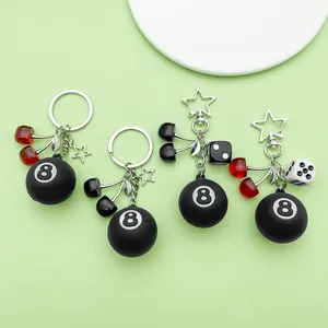 Detailed view of resin cherry and 8-ball billiard charms on star-shaped keychains