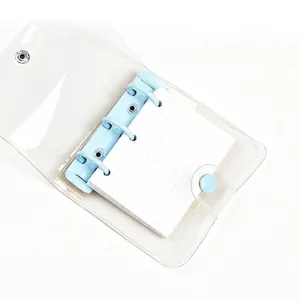 Mini 3-hole transparent PVC binder notebook with light blue rings and grid paper inserts.