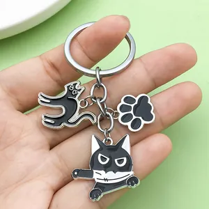 Gros plan détaillé d'un porte-clés chat noir avec un charm de chat tenant un couteau