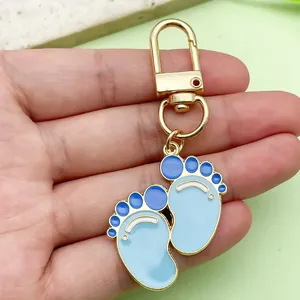 Detailed macro shot of blue baby footprint enamel keychain with gold-tone alloy hardware