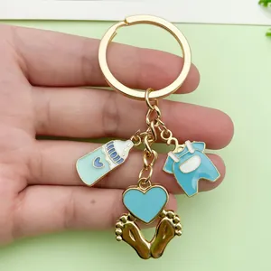Detailed view of baby-themed enamel keychain with bottle, onesie, and heart charms.