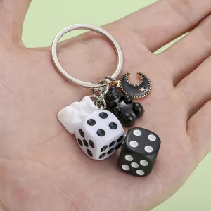 Close-up of cute resin keychain charms featuring black and white dice and bear motifs
