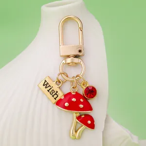 Close-up of cute red mushroom keychain with gold Wish plaque and red rhinestone charm