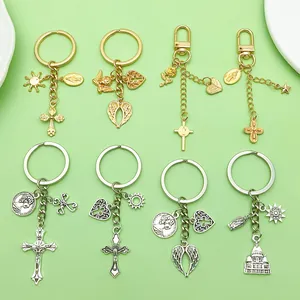 Detail showing a collection of vintage alloy keychains with religious cross and sun pendants.