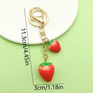 Detailed macro view of red strawberry keychain charm with 11.3cm size dimensions labeled