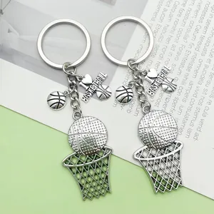 Close-up view of two silver alloy hip-hop basketball hoop and ball charm keychains