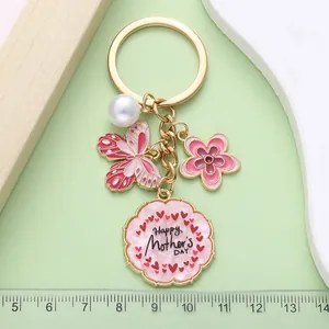 Detalle del llavero mariposa rosa flor perla amuleto regalo del día de la madre en una regla