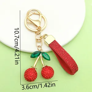 Detailed view of red rhinestone cherry keychain with dimensions 10.7cm x 3.6cm.