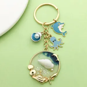 Sleutelhanger met oceaanthema met blauwe dolfijn octopus en schelpbedeltjes voor tassen