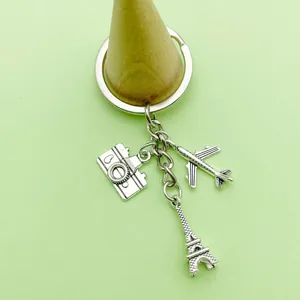Detailweergave van een reissleutelhanger met Eiffeltoren- en vliegtuigbedeltjes.