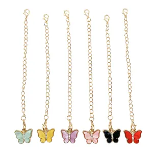 Detailed view of six colorful butterfly charms with rhinestone accents and gold chains