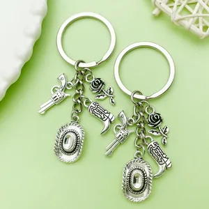 Detailed view of silver Western cowboy keychain with revolver boot rose and hat charms