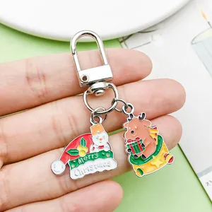 Close-up of Merry Christmas hat and reindeer enamel charms on a silver keychain