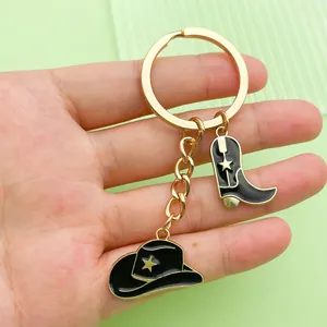 Detail view of western cowboy keychain featuring black enamel hat and boot pendants