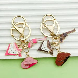 Close-up of Western cowboy theme keychains featuring hat, gun, and star bandana charms.