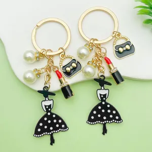 Detalle de llaveros de esmalte con dijes de lápiz labial y bolso retro para bolsos.