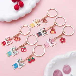 Detailed close-up of colorful Chinese lion dance enamel keychains on pink background