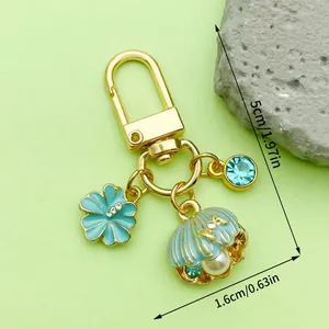 Close-up of ocean themed shell keychain with dimensions 5cm x 1.6cm in gold and light blue