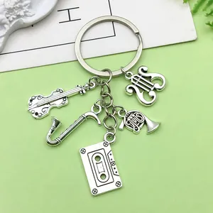 Detailed view of vintage silver musical instrument keychain featuring violin and sax