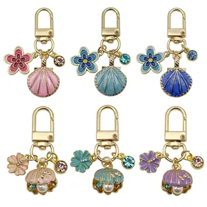 Detailed view of six colorful enamel ocean shell keychains with pearls and sparkling gems