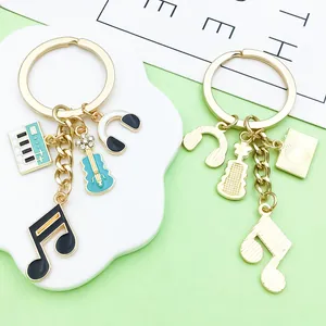 Detailed macro view of gold alloy musical themed keychains with piano and guitar charms
