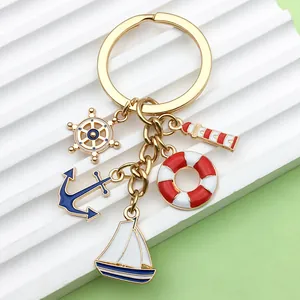 Close-up of nautical enamel charms including a sailboat, lighthouse, anchor and lifebuoy.