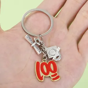 Detalle de llavero de graduación con un pergamino y un colgante rojo con el número 100