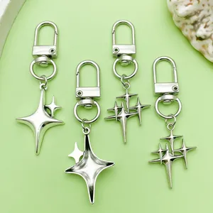 Detailed view of four silver metal keychains featuring unique four-pointed star designs.
