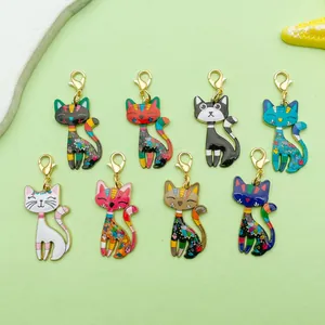 Detail view of colorful enamel cat pendants with intricate floral patterns and gold clasps