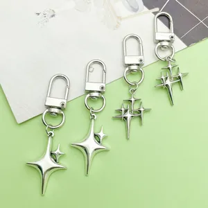 Detail shot of four-pointed star metal keychains in silver for backpack accessories