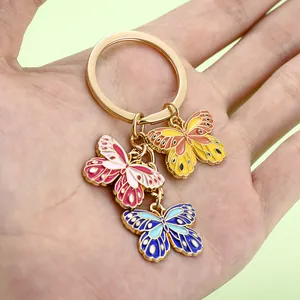 Detailansicht der farbenfrohen Emaille-Schmetterlingsanhänger an einem goldenen Ring