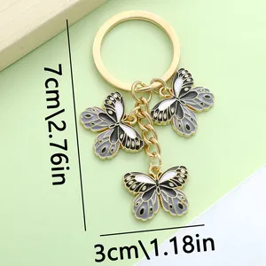 Dettaglio portachiavi a farfalla con dimensioni 7cm x 3cm su sfondo verde