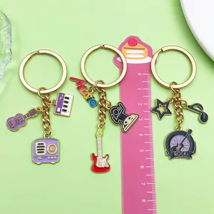 Detailed view of music-themed keychains with guitar and piano charms next to a ruler.