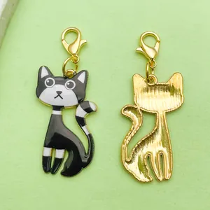 Detail view of black enamel and gold alloy cartoon cat charms with lobster clasps