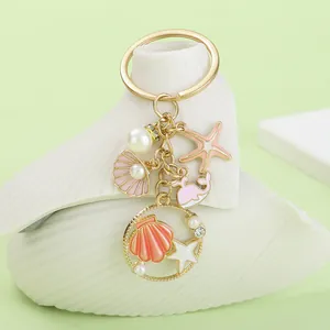 Close-up of ocean series keychain with enamel shell, starfish, and pearl charms