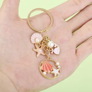 Detailed close-up view of an ocean-themed keychain with shell, pearl, and starfish charms
