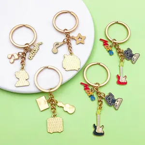 Detailed macro view of gold enamel music themed keychains with guitar and note charms