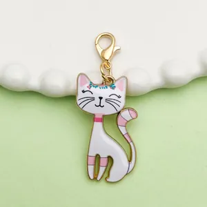 Detailed macro shot of white cartoon cat enamel charm with golden lobster clasp accessory