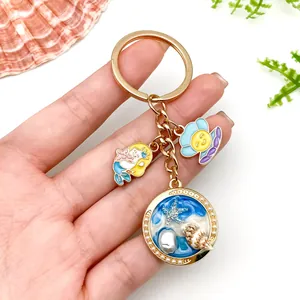 Detailed view of gold-plated ocean-themed keychain with shell and starfish charms.